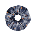 A fabric hair scrunchie featuring a navy blue and gray tie-dye pattern with a repeating orange and blue 'G' logo, shown on a plain white background.
